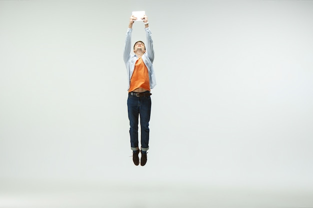 Free photo happy young man working at office, jumping and dancing in casual clothes or suit isolated on white background.