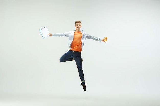 Free Photo happy young man working at office, jumping and dancing in casual clothes or suit isolated on white  background.