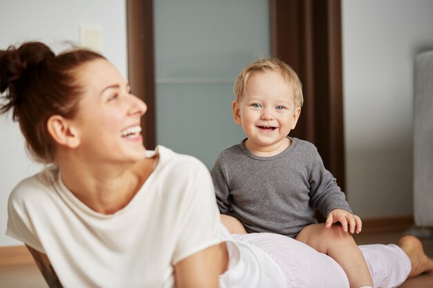 Happy young mother with little son at home