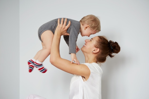 Happy young mother with little son at home