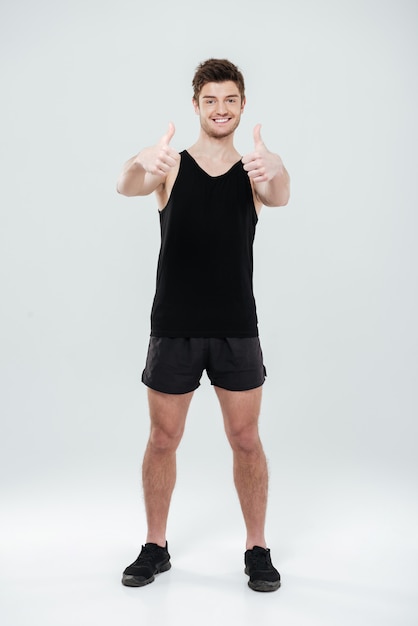 Happy young sportsman showing thumbs up gesture.