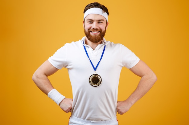 Free Photo happy young sportsman with medal looking at camera.