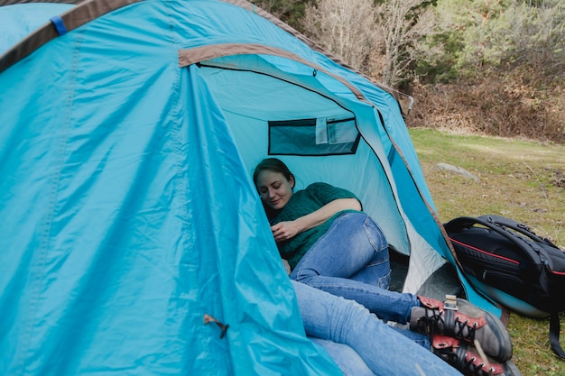 Free photo happy young woman in a blue tent