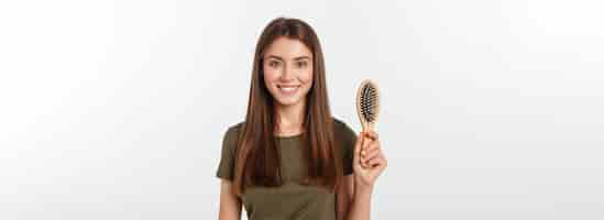 Free photo happy young woman combing her long healthy hair on white background