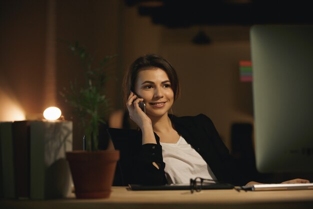 Happy young woman designer talking by phone