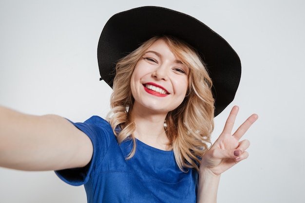 Happy young woman make selfie posing