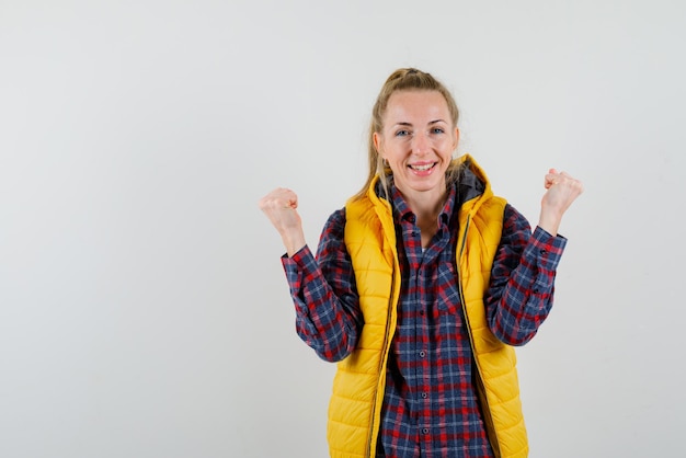 Free photo happy young woman showing her fists on white background