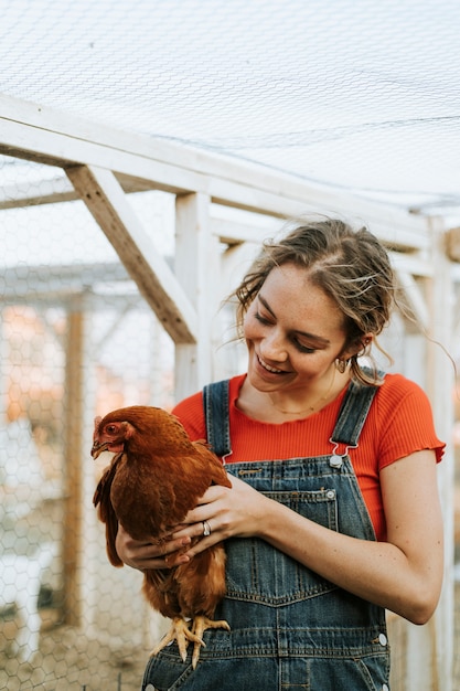 Free photo happy young woman with a brown hen