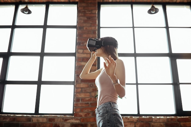 Free photo happy young woman with vr headset. playing at home