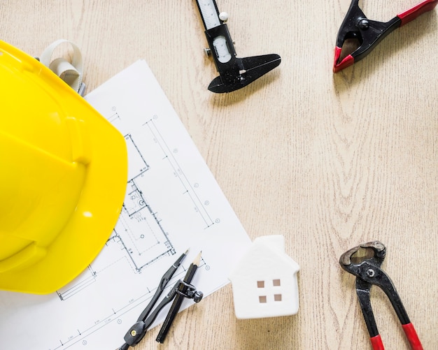 Hardhat near blueprint and construction tools