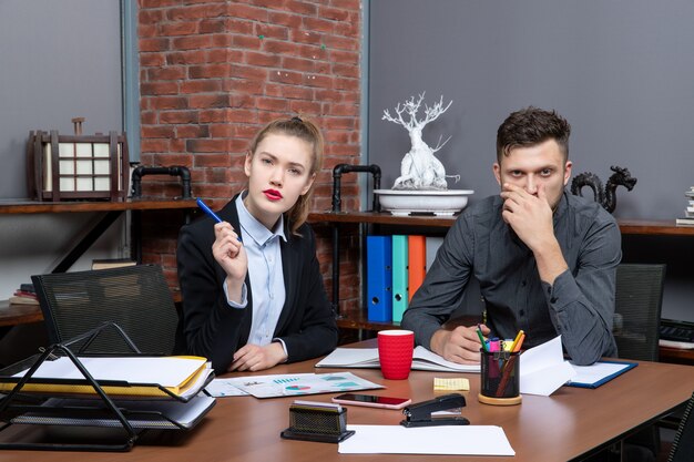 Hardworking and confused management team discussing one issue in the documents in the office