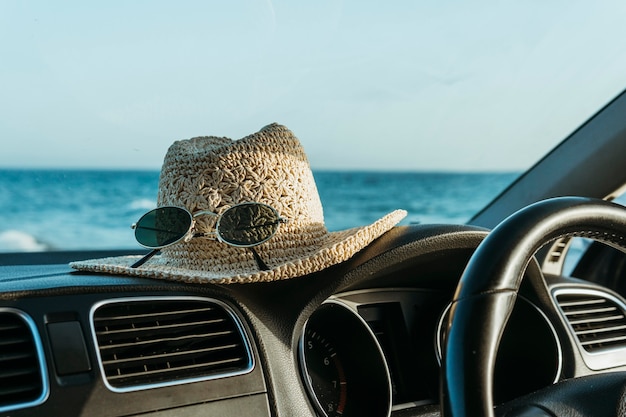 Hat and sunglasses on car board