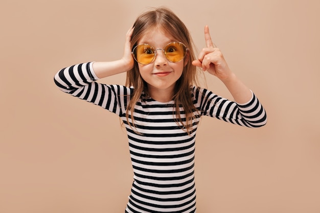 Having fun, expressing true positive emotions of joyful amazing young girl over isolated on beige background.