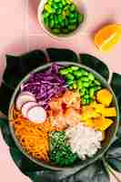 Free photo hawaiian poke bowl with salmon in a bowl with seaweed sesame seeds and cabbage top view flat lay vertical