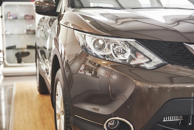 The headlights and the hood of a black luxury car.