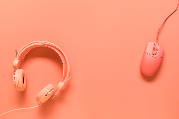 Free photo headphones and mouse on orange background