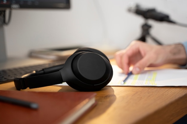 Free Photo headphones for podcasting sitting on the table next to man