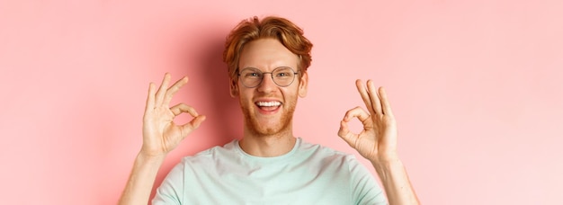 Free photo headshot portrait of attractive young man with messy red hair and beard wearing glasses smiling with