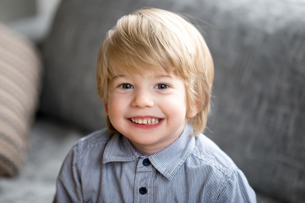 Headshot portrait of cute smiling kid boy looking at camera