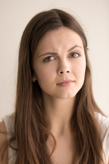 Headshot portrait of skeptic young woman