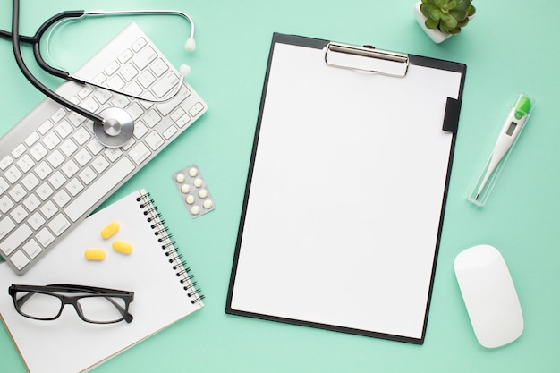 Healthcare accessories with clipboard and modern devices over green background