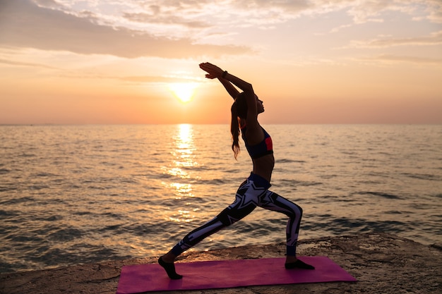 Healthy attractive woman doing exercises for body, practicing yoga