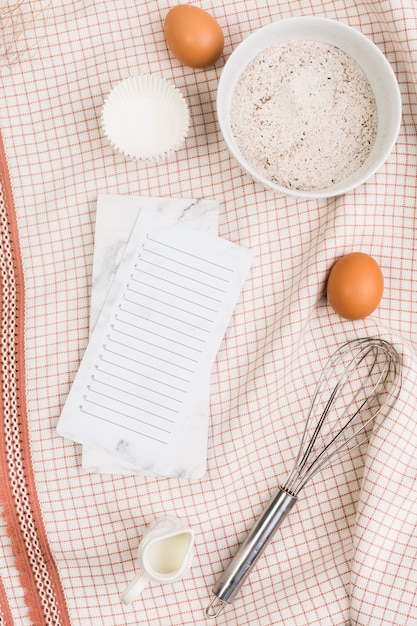 Free Photo healthy baking ingredients with empty checklist over kitchen napkin