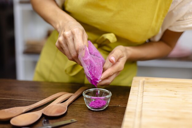 Healthy breakfast chia pudding making process. Woman mix chia seeds, almond milk and natural color dragon fruit pink extract in blender.