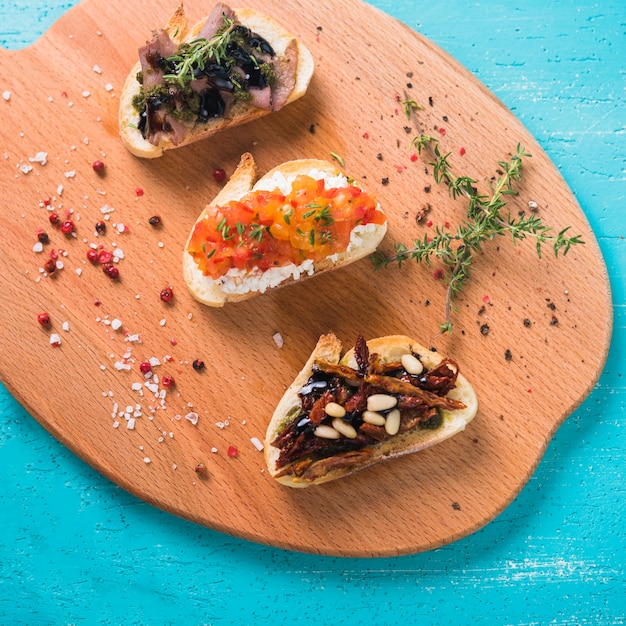 Free photo healthy breakfast toast with thyme; red peppercorn seed and salt on chopping board