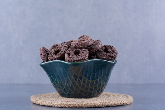 Healthy breakfast with chocolate corn rings in a plate on a stone.