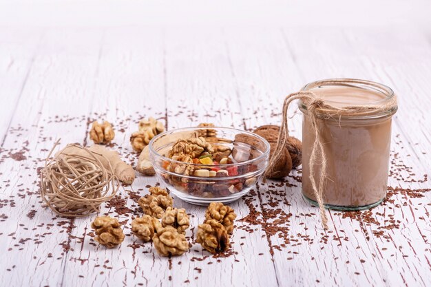 healthy brown smoothie with walnut and candied fruits lie on the table