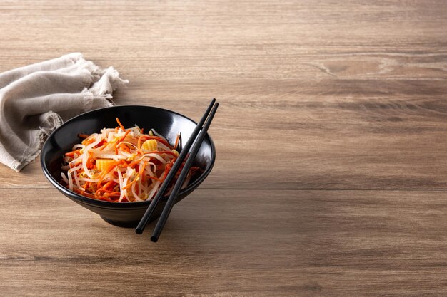 Healthy Chinese cabbage salad in bowl on wooden table