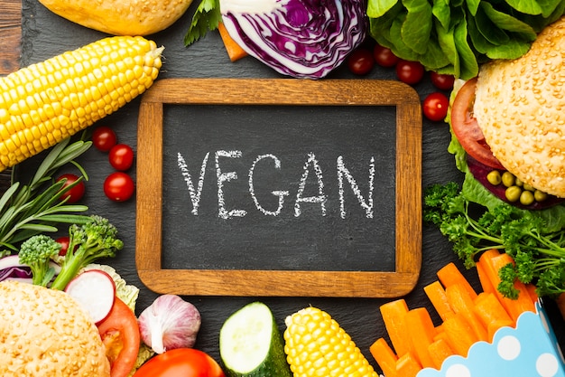 Healthy food arrangement with vegan lettering on chalkboard