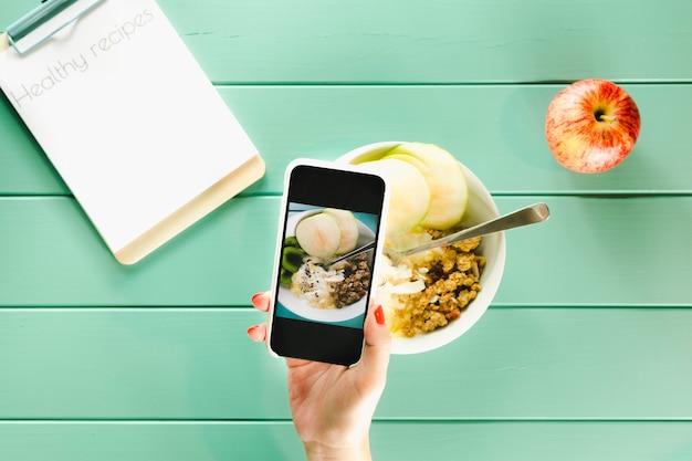 Free photo healthy food concept with hand holding smartphone and clipboard