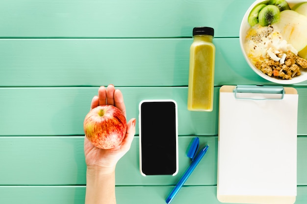 Free photo healthy food concept with smartphone clipboard and apple