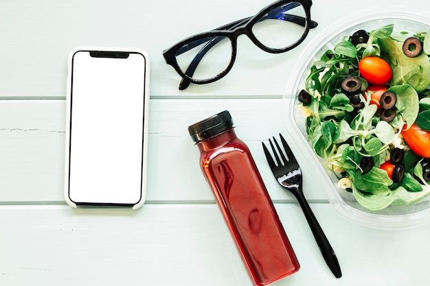 Healthy food concept with smartphone juice and salad