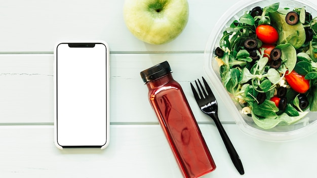 Healthy food concept with smartphone next to salad