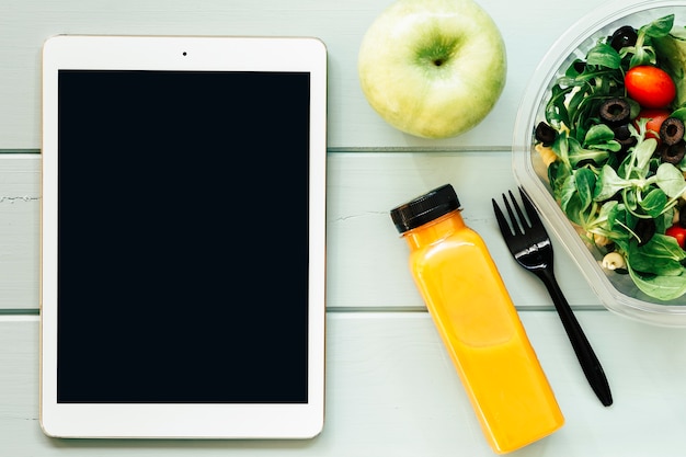 Free photo healthy food concept with tablet and salad