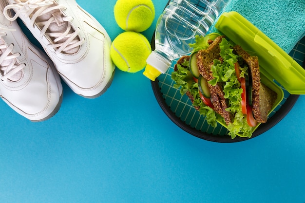 Free photo healthy life sport concept. towel, healthy sandwich and bottle of water on bright background. copy space. above.