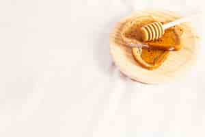 Free photo healthy natural honey and bread in plate over white cloth