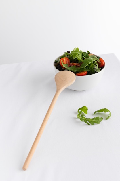 Free photo healthy salad in white bowl on a white table