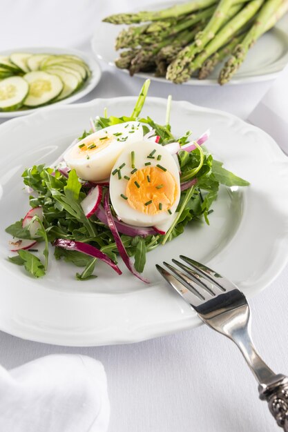 Free Photo healthy salad with egg on a white plate composition