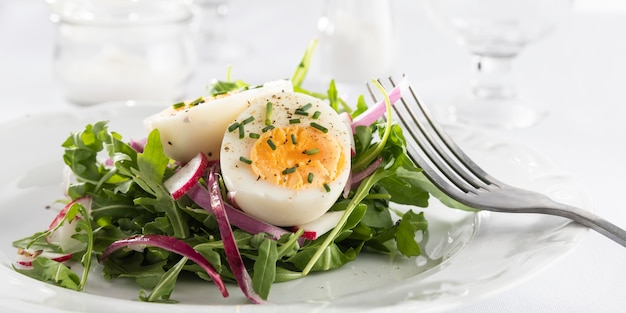 Free photo healthy salad with egg on a white plate