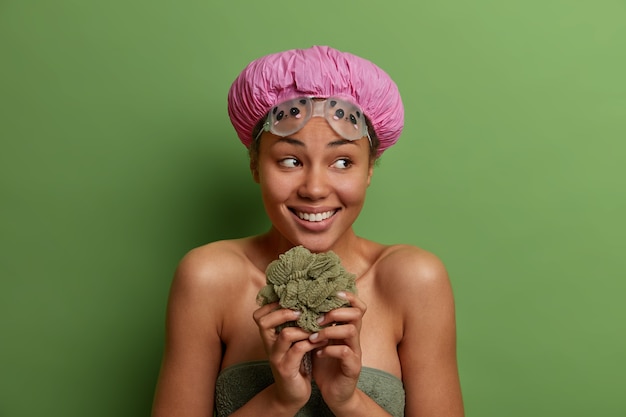 Healthy smiling female model wrapped in bath towel