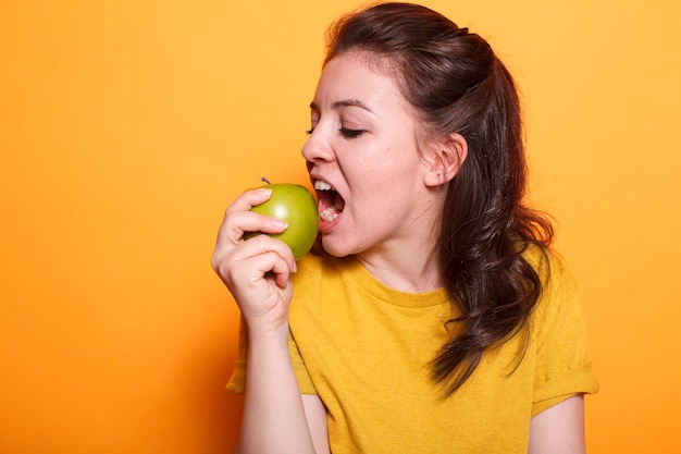 Free photo healthy woman biting a green apple