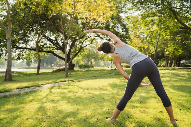 Free photo healthy young asian runner woman warm up the body stretching before exercise and yoga