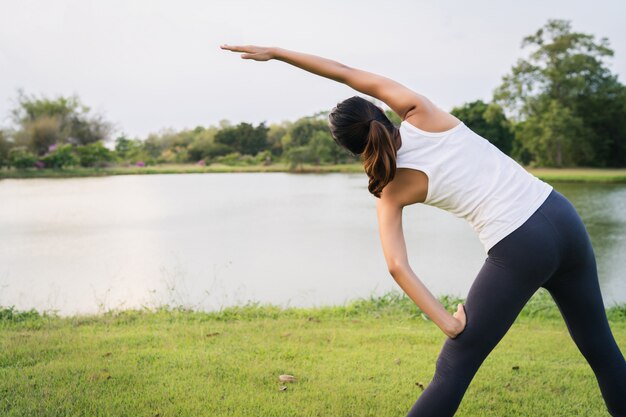 Healthy young Asian runner woman warm up the body stretching before exercise and yoga