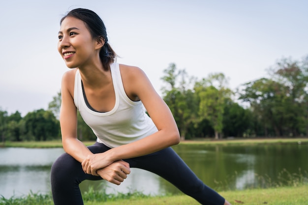 Healthy young Asian runner woman warm up the body stretching before exercise and yoga