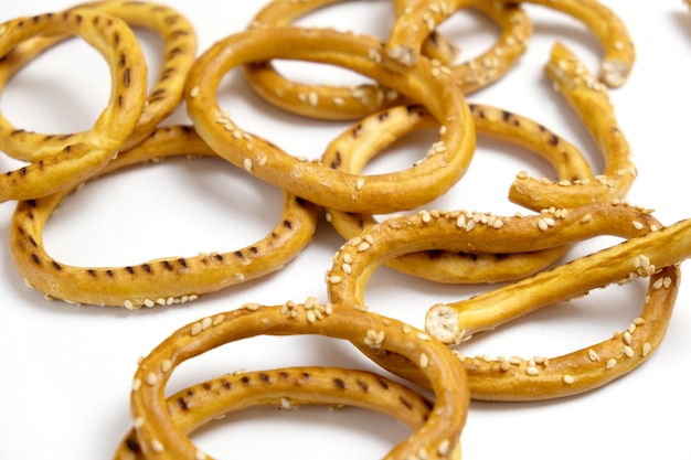 Heap of bagels with sesame seeds on white background