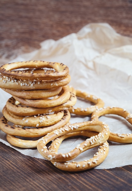 Heap of bagels with sesame seeds on wooden background